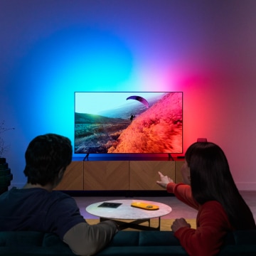 一对夫妇正在享受与电视屏幕颜色同步的 LED 灯光效果。